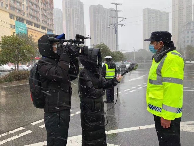 孝感市融媒體中心楊亞玲（風(fēng)雪中，采訪疫情期間重返一線的退休警察）_副本.jpg.jpg